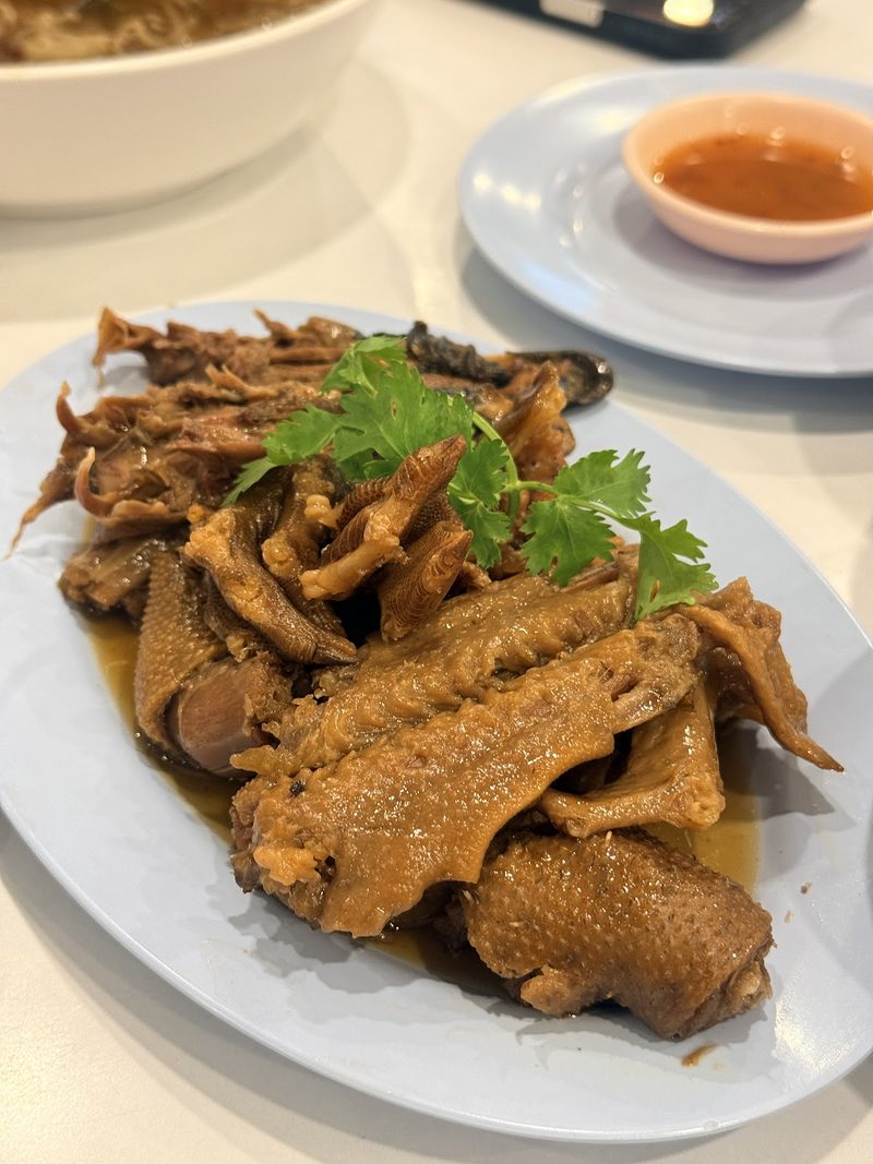 จานปีก คอ และขาเป็ดพะโล้ ราดน้ำพะโล้ มีผักชีและถ้วยน้ำจิ้ม