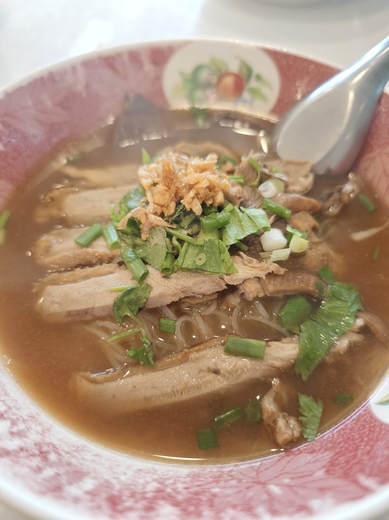 ก๋วยเตี๋ยวเป็ดลอกในชามลายดอก เนื้อเป็ดสไลซ์ กระเทียมเจียว และผักชี